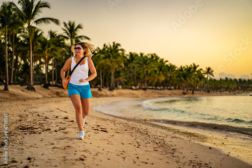 Beach holiday - beautiful woman walking, running on sunny, tropical beach

