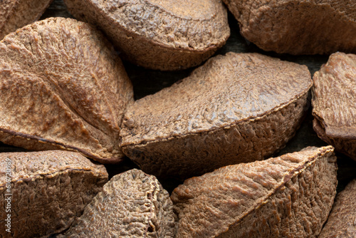 Unshelled Brazil nuts pile close-up background.