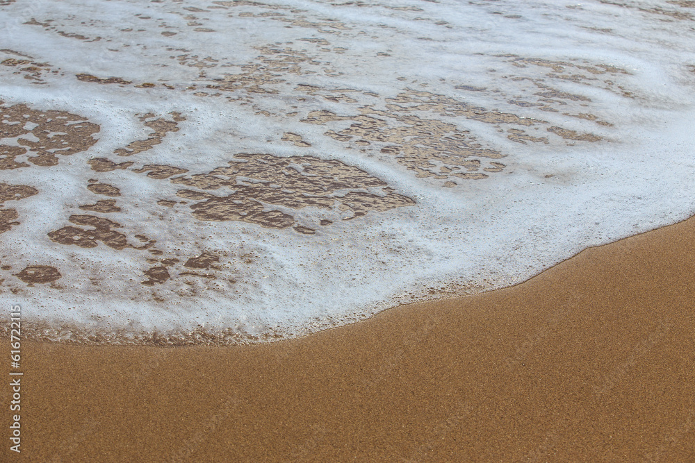 Sea foam on the sandy beach