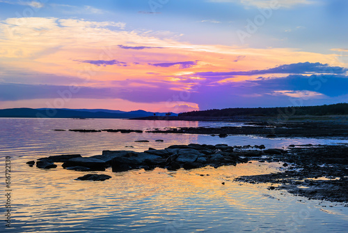 Beautiful sunset on the rocky shore of the lake