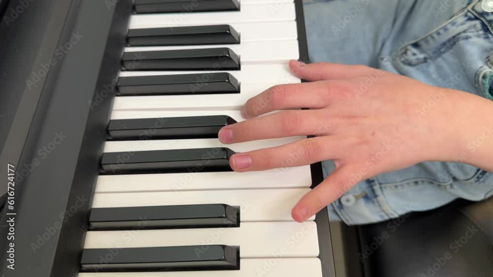 a little girl playing the piano at home, a girl playing a musical instrument, the hands of a child playing the piano close-up a little girl playing the piano at home, a girl playing a musical instrument, the hands of a child playing the piano close-up