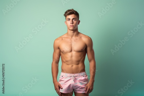 Fictional muscular young man modeling for swim short. Isolated on colorful background. Generative AI illustration.