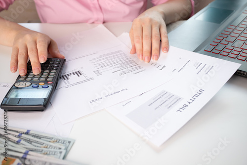 Utility Receipt, Power bill with electricity and gas charges, a woman at her desk counts the cost of utility bills, woman at home counting utility bills on a calculator