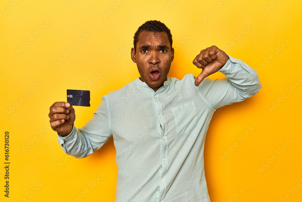 African American man with credit card, yellow studio, feels proud and self confident, example to follow.