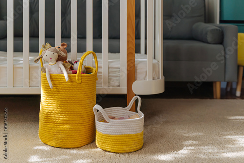 Yellow Toy Storage Baskets in the children's room. Cloth stylish Baskets with toys. Organizing and Storage Ideas in nursery. Clean up toys and  reduce the clutter.