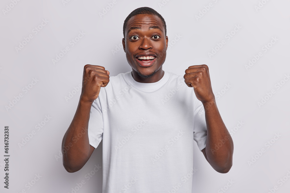 Exuberant African man radiates joy as he clenches his fists and lets out euphoric scream his beaming smile and contagious energy convey profound sense of happiness positivity routs for favorite team Exuberant African man radiates joy as he clenches his fists and lets out euphoric scream his beaming smile and contagious energy convey profound sense of happiness positivity routs for favorite team