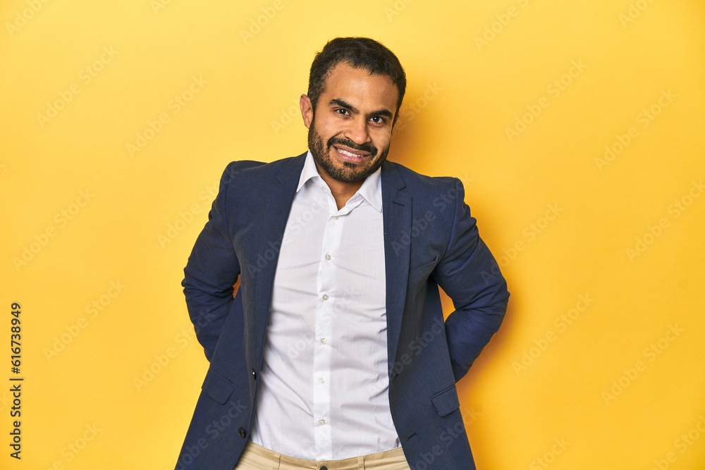 Professional young Latino man in business suit, yellow studio background, happy, smiling and cheerful. Professional young Latino man in business suit, yellow studio background, happy, smiling and cheerful.