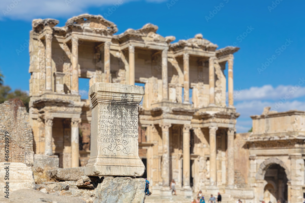 Celsus Library and stone with Ancient Greek inscription (Ancient law in greek language). Scenic view on magnificient ruins of the ancient city of Ephesus. Selcuk (Izmir region). Turkey