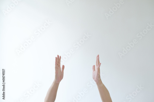 The hands of man are going to pose pray or adore something. Isolated white background.