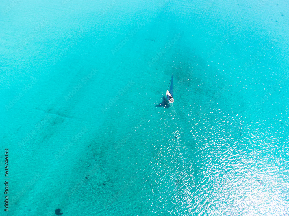 Aerial view of a boat sailing on the turquoise water