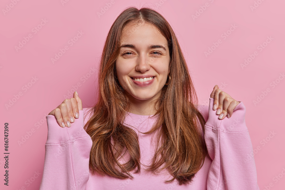 Happy long haired young woman clasps