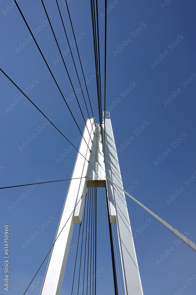 Modern urban cable-stayed bridge with metal ropes over cloudless blue sky Modern urban cable-stayed bridge with metal ropes over cloudless blue sky