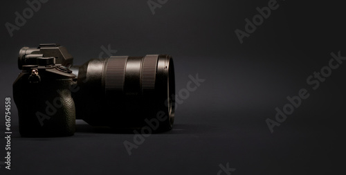 Photo camera on dark background. Side view. Copy space. Horizontal banner photo