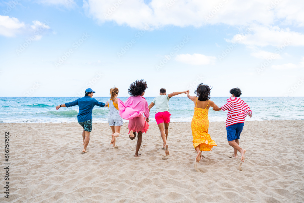 Group of young best friends bonding outdoors - Multiracial happy people having party at the beach during summertime