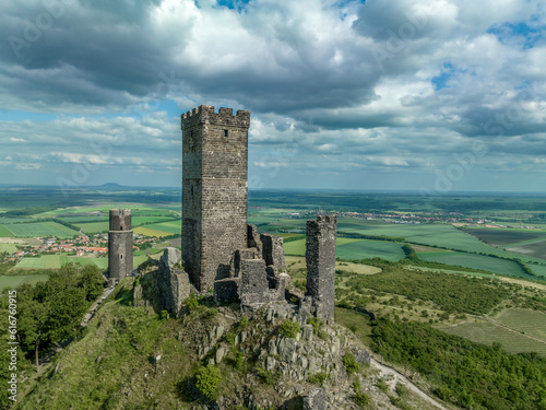 Aerial view of the remains of Hazmburk medieval castle with a circular and rectangular tower sit at the summit of this low peak hiking spot with scenic views.  © tamas