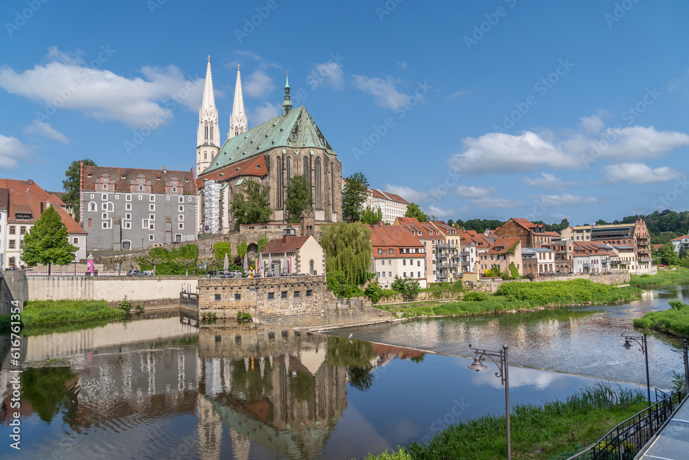 Pfarrkirche St. Peter und Paul Landmark Gothic evangelical church noted for its soaring twin spires, copper roof in Gorlitz Germany reflecting off the Niesse river