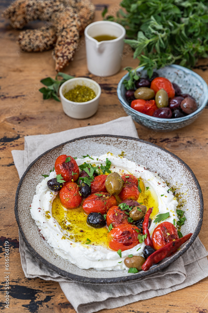Popular middle eastern appetizer labneh  .Cream cheese dip with olive oil, Cherry tomatoes,cucumber, herbs and olives