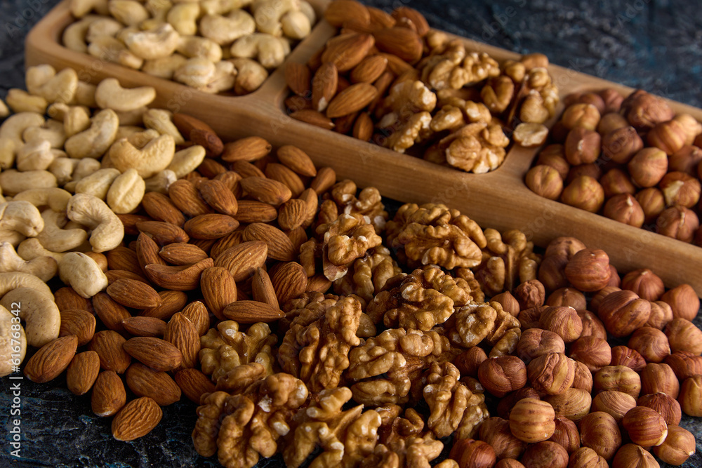 Assortment of goods from different dried delicious healthy nuts in the store. Healthy nut mix for a healthy snack in a pile on a gray table Assortment of goods from different dried delicious healthy nuts in the store. Healthy nut mix for a healthy snack in a pile on a gray table