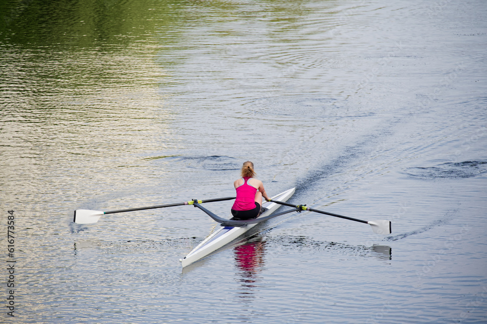Women training on canoe to practise rowing during early morning on river Women training on canoe to practise rowing during early morning on river