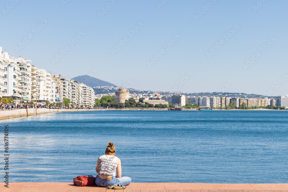People relaxing along the bay of the Aegean Sea with white tower view in the center of Thessaloniki in Central Macedonia in Greece