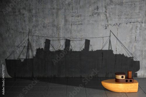 Concept of hidden potential. A wooden toy ship that casts the shadow of a real large ship. 3D illustration photo