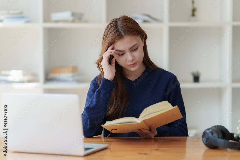 Sad teenager studying preparing for exam test in the university library. Depressed young woman student. Back to School concept Sad teenager studying preparing for exam test in the university library. Depressed young woman student. Back to School concept