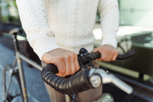 Selective focus, closeup of man holding handlebars of rental bicycle. Concept of rental transport