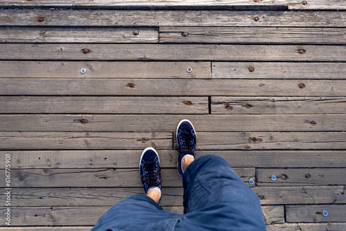 Point of view man walk on wooden floor. A man with blue shoes and shorts jeans walking alone on old wooden ground. 