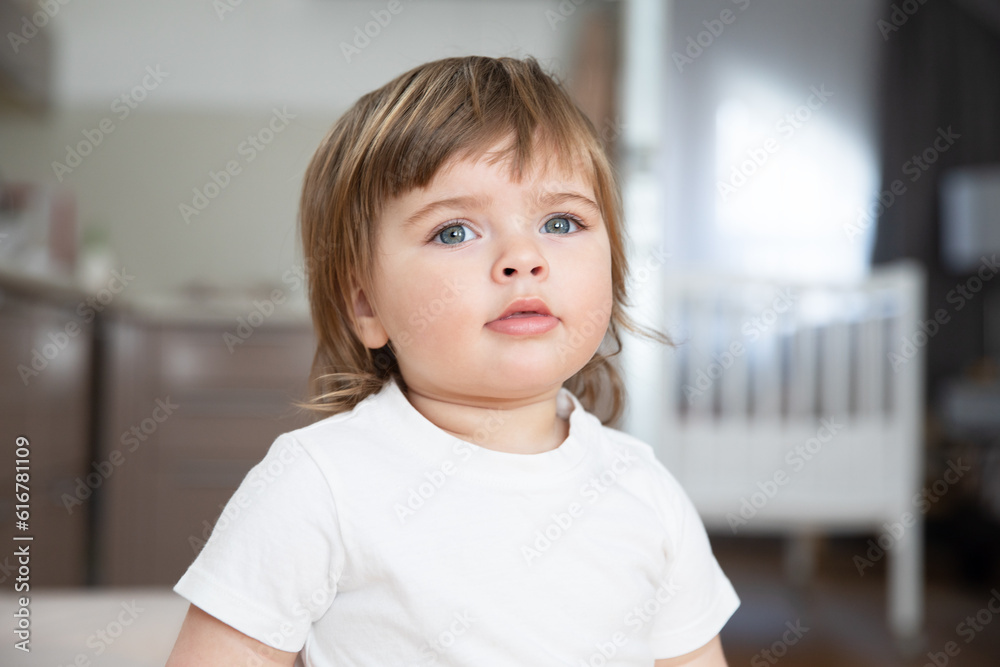 Portrait of a cute beautiful Caucasian baby with plump lips and blue eyes in a white T-shirt. Portrait of a cute beautiful Caucasian baby with plump lips and blue eyes in a white T-shirt.