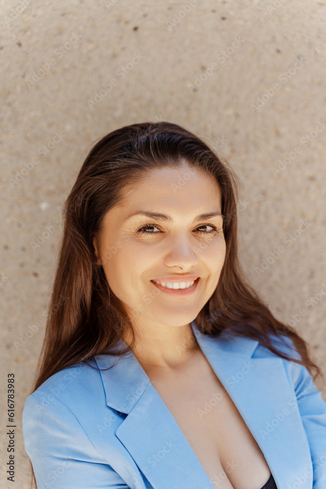 Smiling middle age latin businesswoman looking at camera outdoors. Portrait of confident woman wearing blue suit standing on the street. Successful business concept Smiling middle age latin businesswoman looking at camera outdoors. Portrait of confident woman wearing blue suit standing on the street. Successful business concept