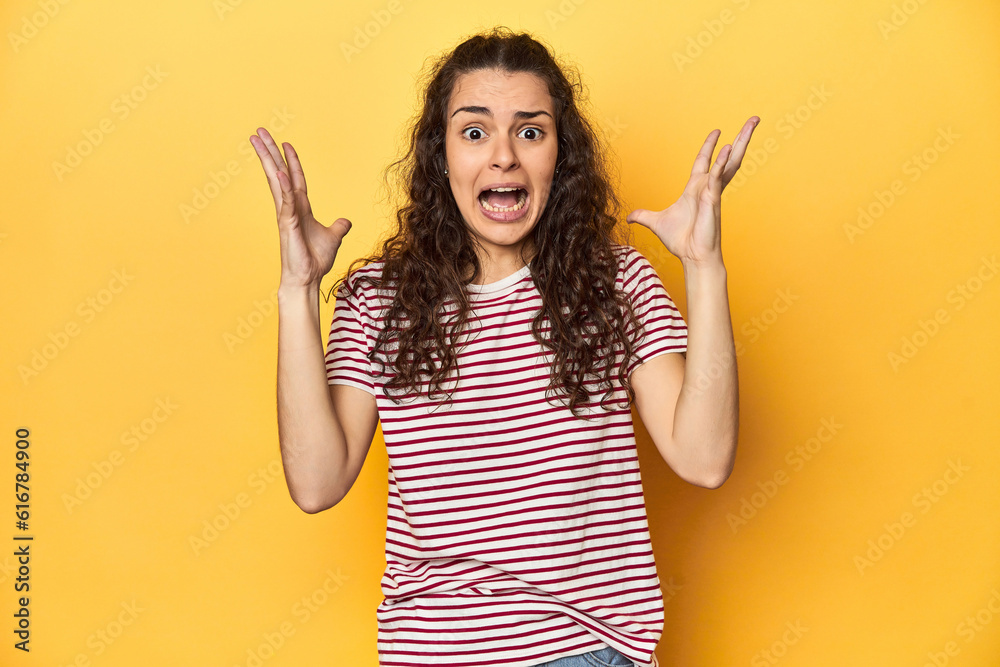 Young Caucasian woman, yellow studio background, screaming to the sky, looking up, frustrated. Young Caucasian woman, yellow studio background, screaming to the sky, looking up, frustrated.