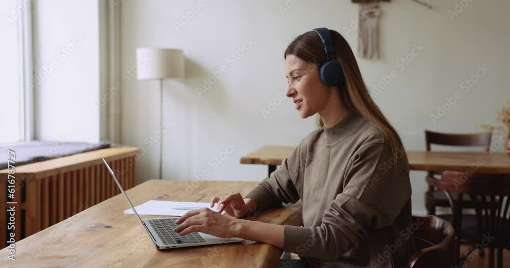 Woman in headphones hold on-line conference with client using laptop and video call application working remotely, provide professional online counselling and information at virtual meeting in office Woman in headphones hold on-line conference with client using laptop and video call application working remotely, provide professional online counselling and information at virtual meeting in office