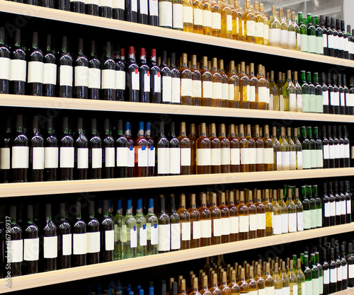 Vine bottles on shelf. Red and White vine bottles on shelves in supermarket interior. Suitable for presenting new Vine bottles and new brand label among many others. 
