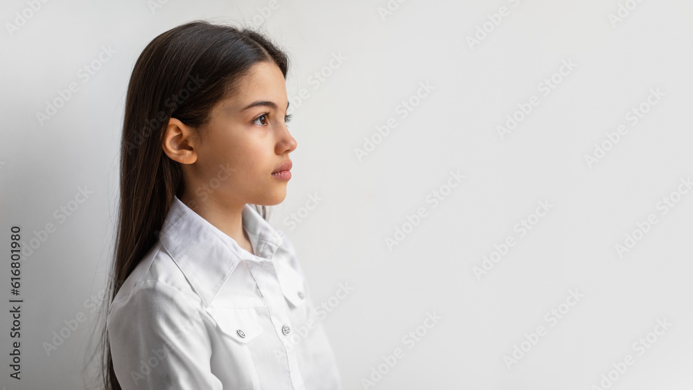 Profile Portrait Of Serious Arabic Preteen Girl Against White Wall Profile Portrait Of Serious Arabic Preteen Girl Against White Wall