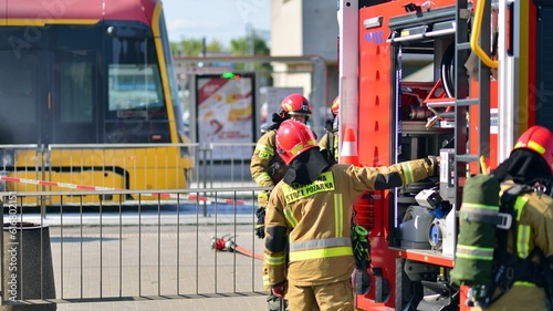 Firemen and burnt tram transport. Fire brigade action. photo