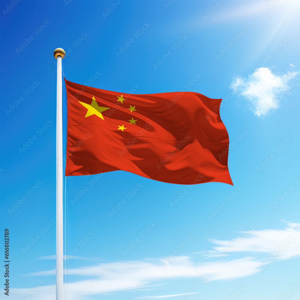 Waving flag of China on flagpole with sky background.