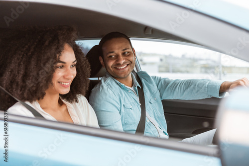Loving young arab man and woman sitting inside new car
