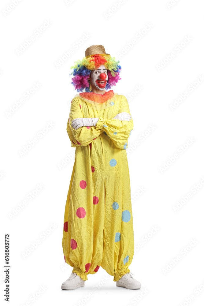 Full length portrait of a clown in yellow clothes posing with crossed arms