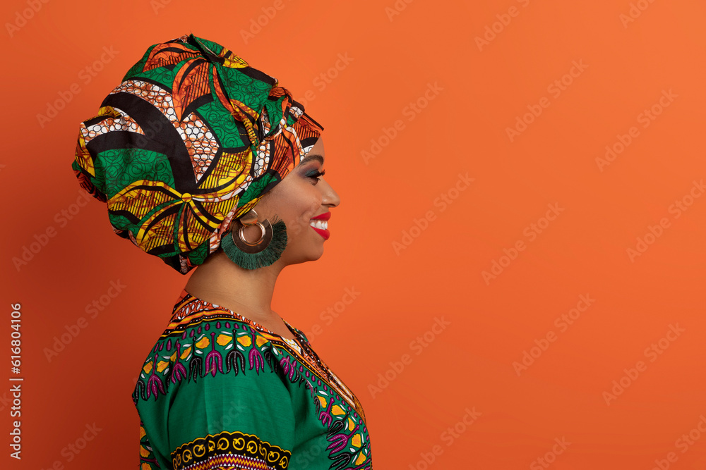 Profile portrait of cheerful black woman in african costume
