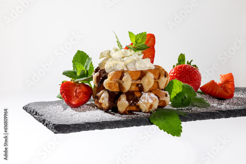 Belgian waffles with strawberries on slate board white background
