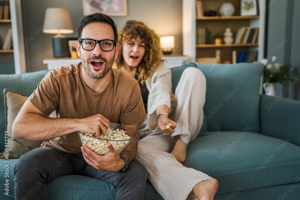 Couple caucasian man and woman sit at home on sofa bed watch tv movie