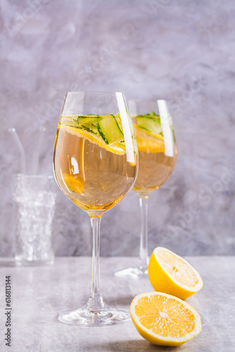 Summer hugo spritz cocktail with champagne, cucumber, lemon and mint in wine glasses vertical