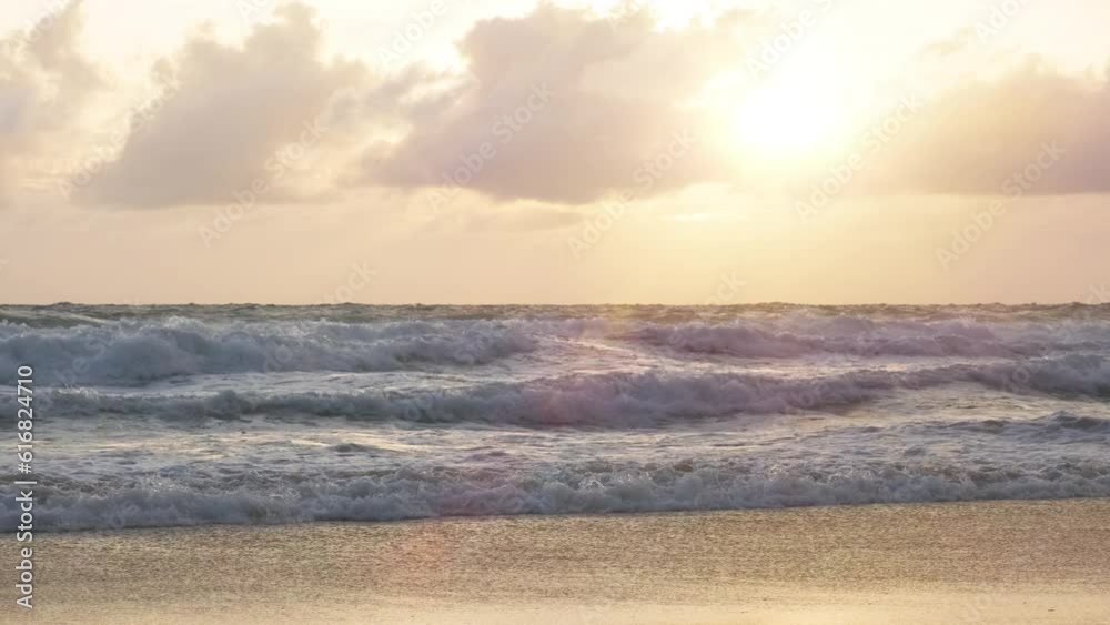 Scenic view of the bright evening sun above the summer ocean. Large waves roll on to the sandy shore and pour out with force. Now is the monsoon season in the subequatorial climate zone, 4k uhd. Scenic view of the bright evening sun above the summer ocean. Large waves roll on to the sandy shore and pour out with force. Now is the monsoon season in the subequatorial climate zone, 4k uhd.