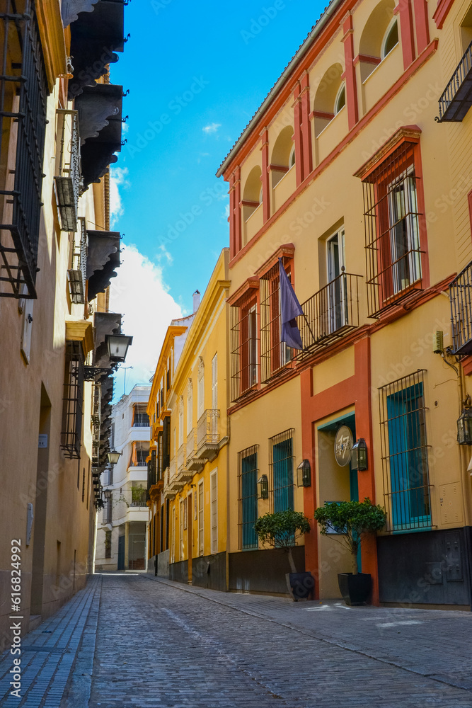 24.05.2023, Cadiz, Spain: Narrow streets of Cadiz with shops, cafes, restaurants and souvenir shops and colorful houses