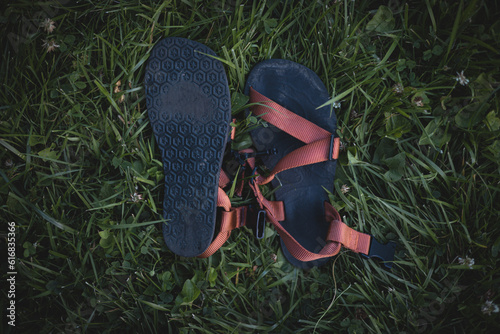 Barefoot orange hiking sandals in grass