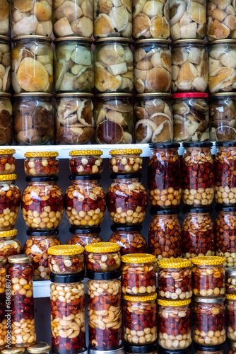 Close-up of glass jars display shelf delicious handmade eco dessert assorted nuts and honey. Shop of farm products in the Ukrainian Carpathians.