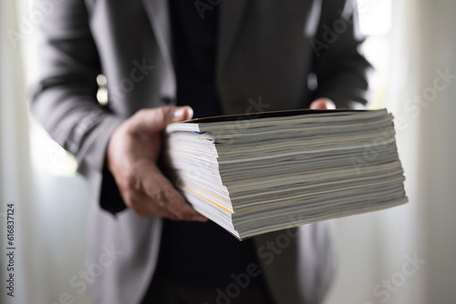 man holding a magazine publication page media stack to stack communication research data to learn advertising and banner space objects