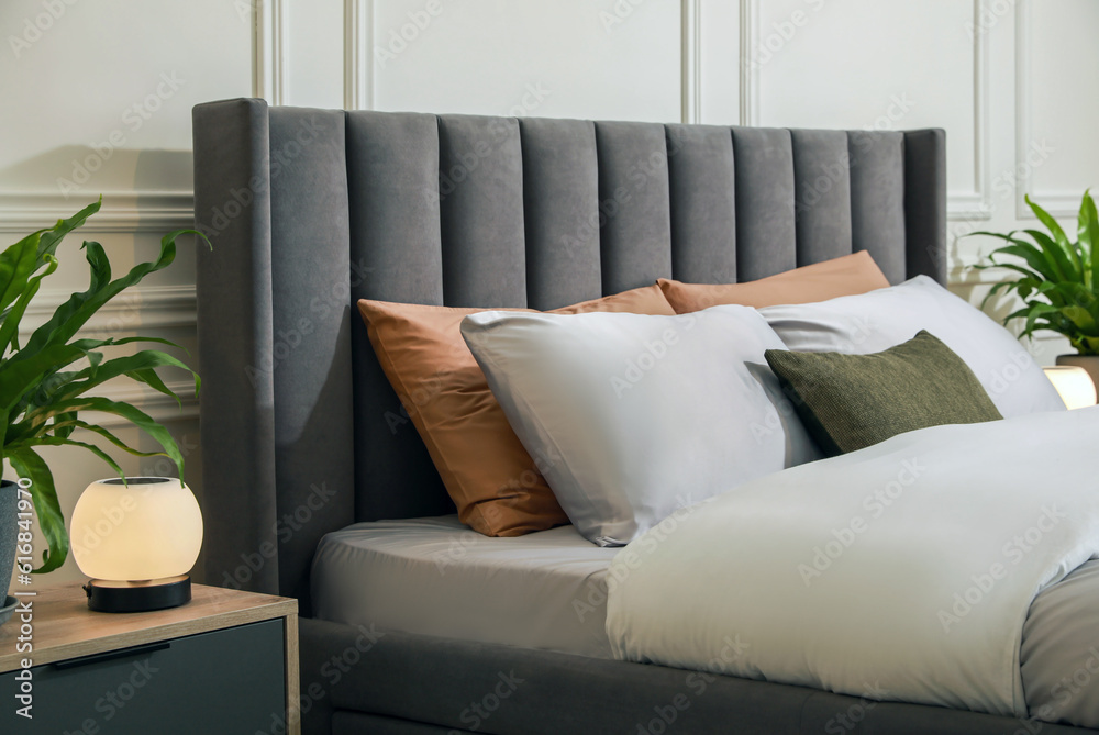 Fototapeta premium Comfortable bed with pillows and bedding in stylish room. Interior design