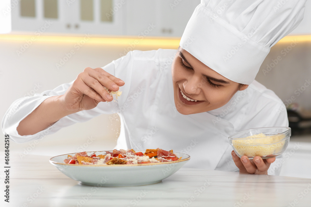 Professional chef adding grated cheese into delicious dish in kitchen Professional chef adding grated cheese into delicious dish in kitchen