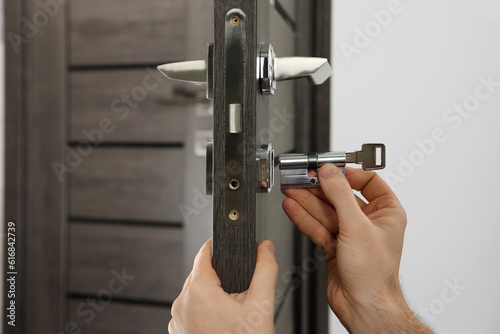 Tableau sur toile Handyman changing core of door lock indoors, closeup